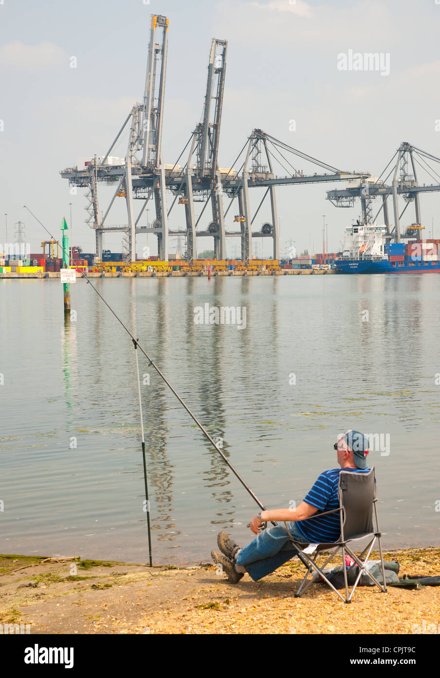 A fisherman relaxes by the harbor. Photographed at Southampton international container port, Hampshire, England,  in May 2012. Stock Photo