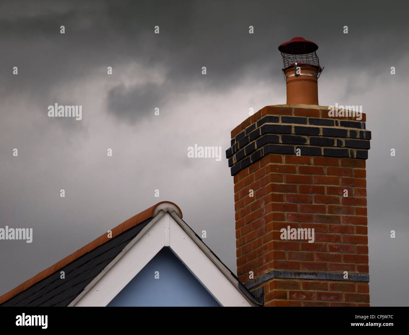 A brick chimney with a stormy sky as a backdrop. Stock Photo