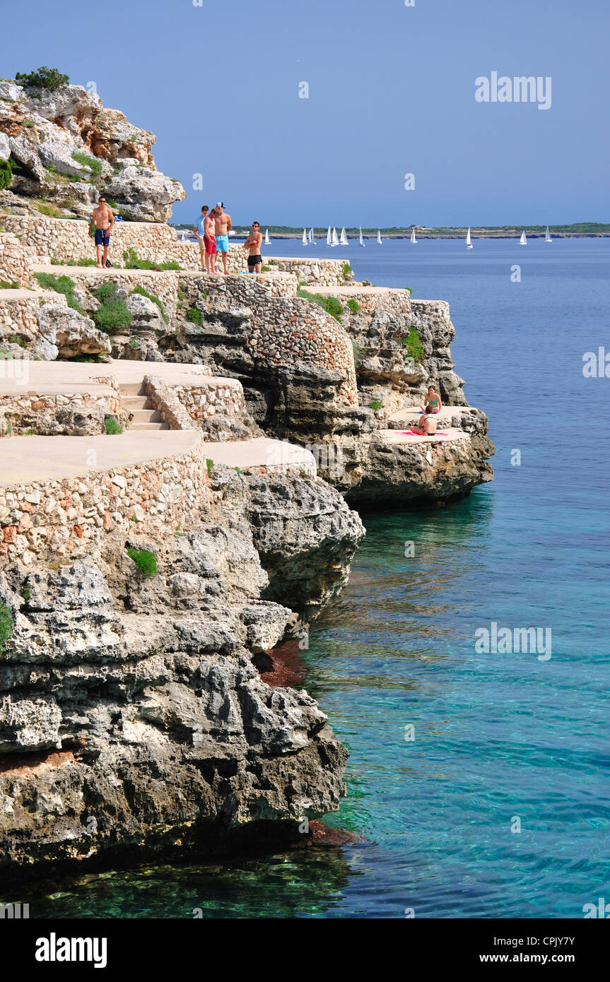 Bathers on rocky ledges, Cala en Forcat, Menorca, Balearic Islands, Spain Stock Photo