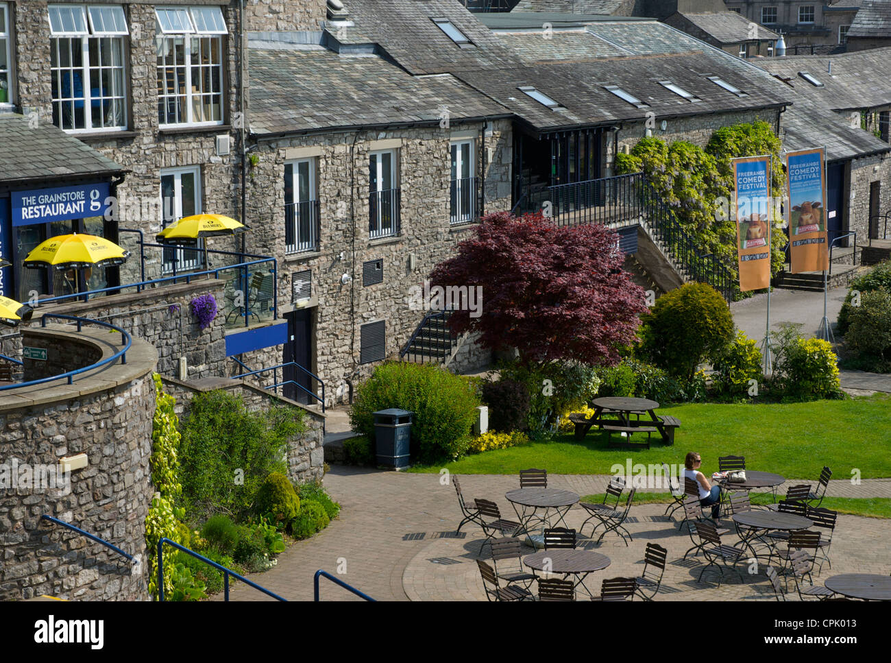 Woman sitting in the garden of the Old Brewery Arts Centre, Kendal, Cumbria, England UK Stock Photo