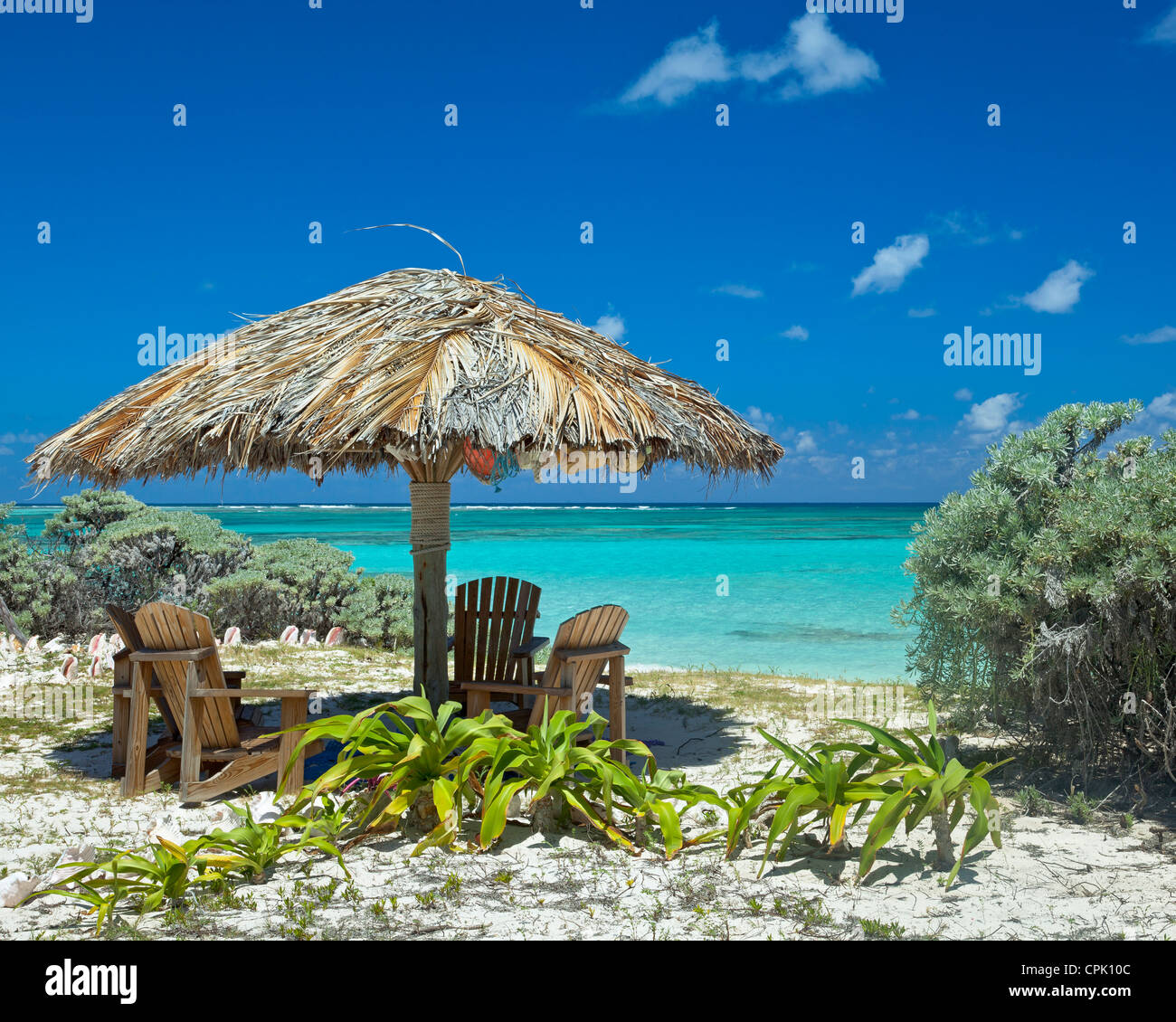 Anegada, British Virgin Islands, Caribbean Adirondack chairs under a palapa at Cow Wreck Bay Stock Photo