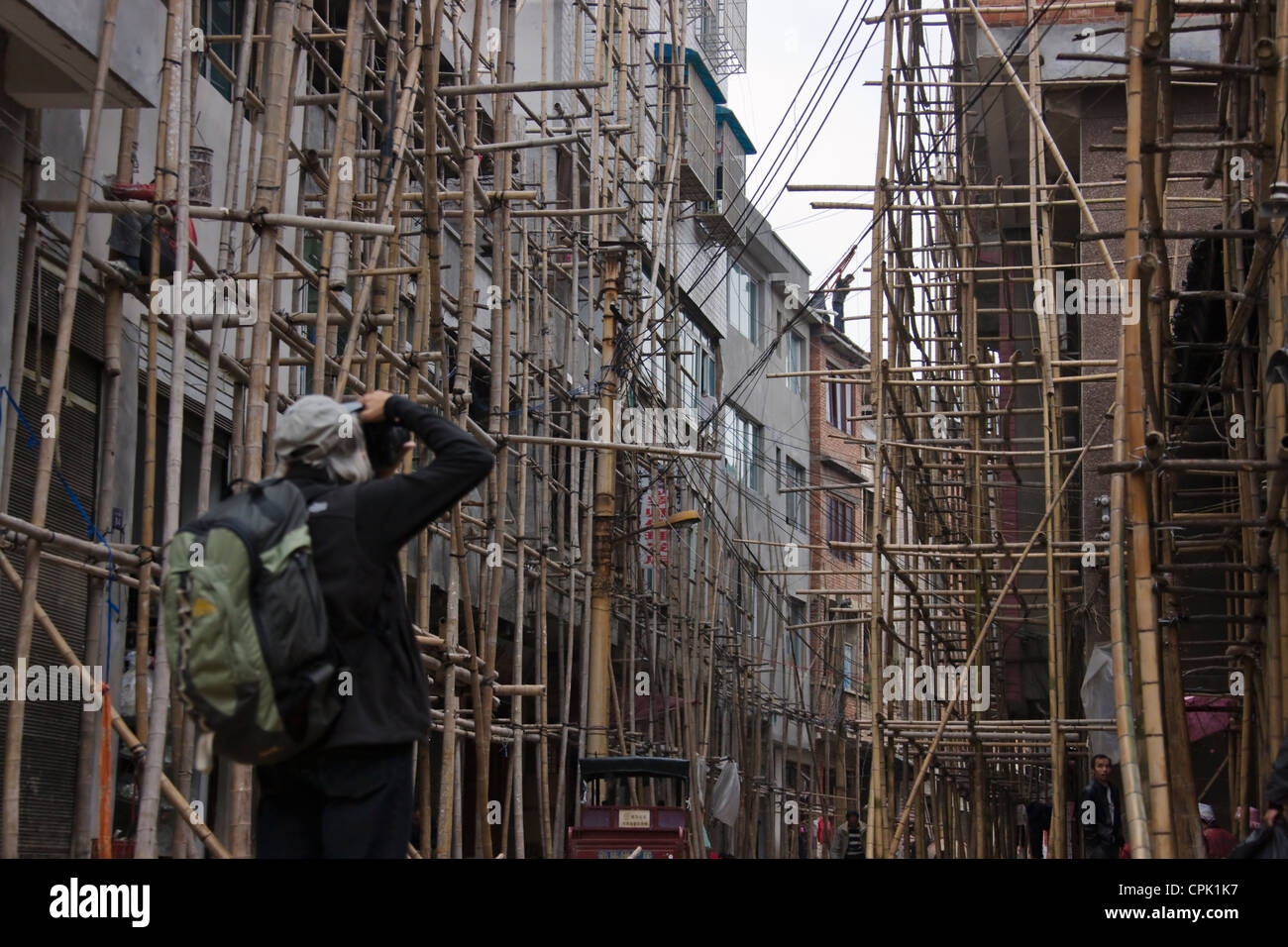 Tourist photographing bamboo scaffolding at a construction site, Kaili, Guizhou, China Stock Photo