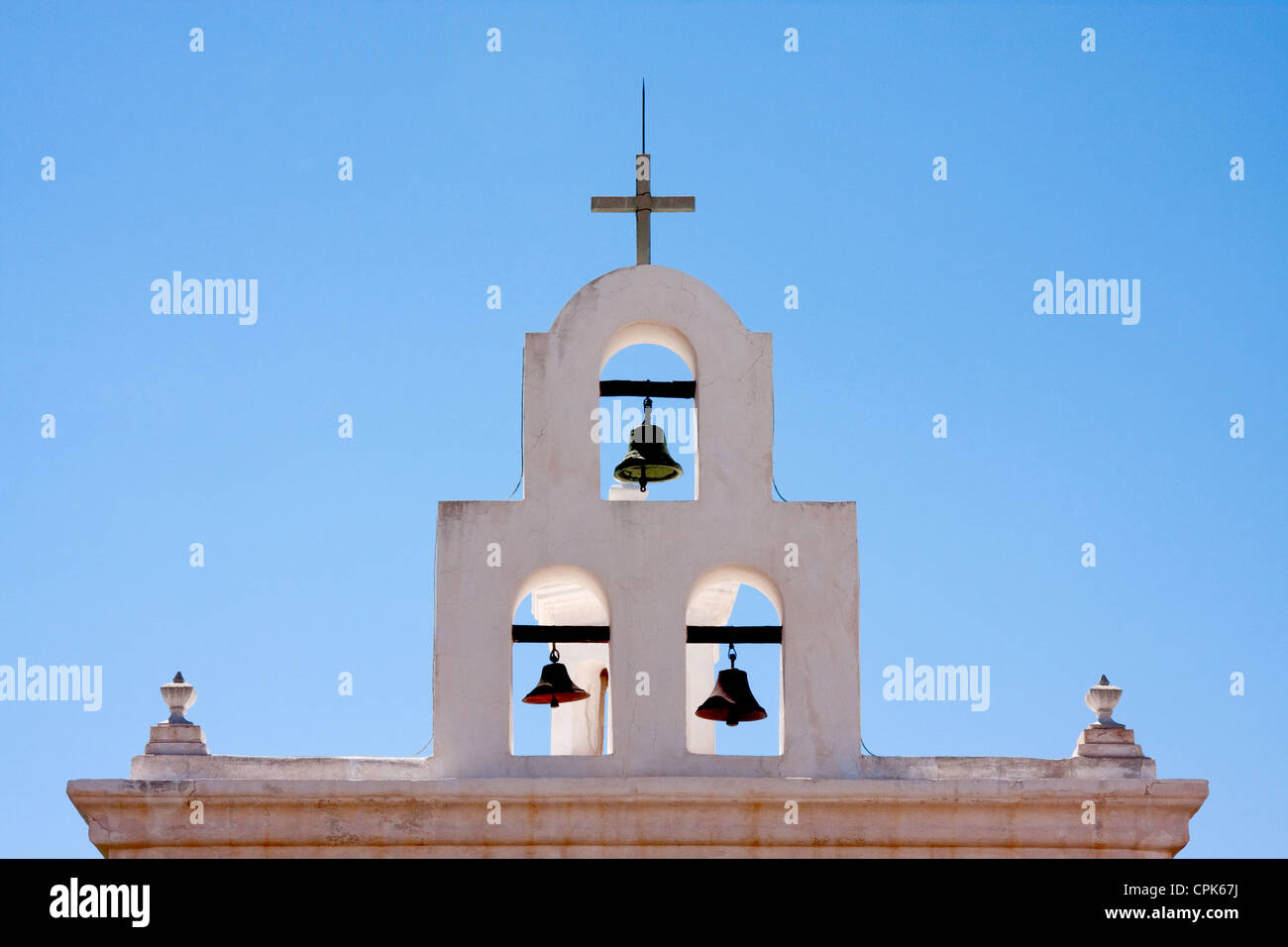 Three church bells adjacent to San Xavier's mission in Tucson, Arizona Stock Photo