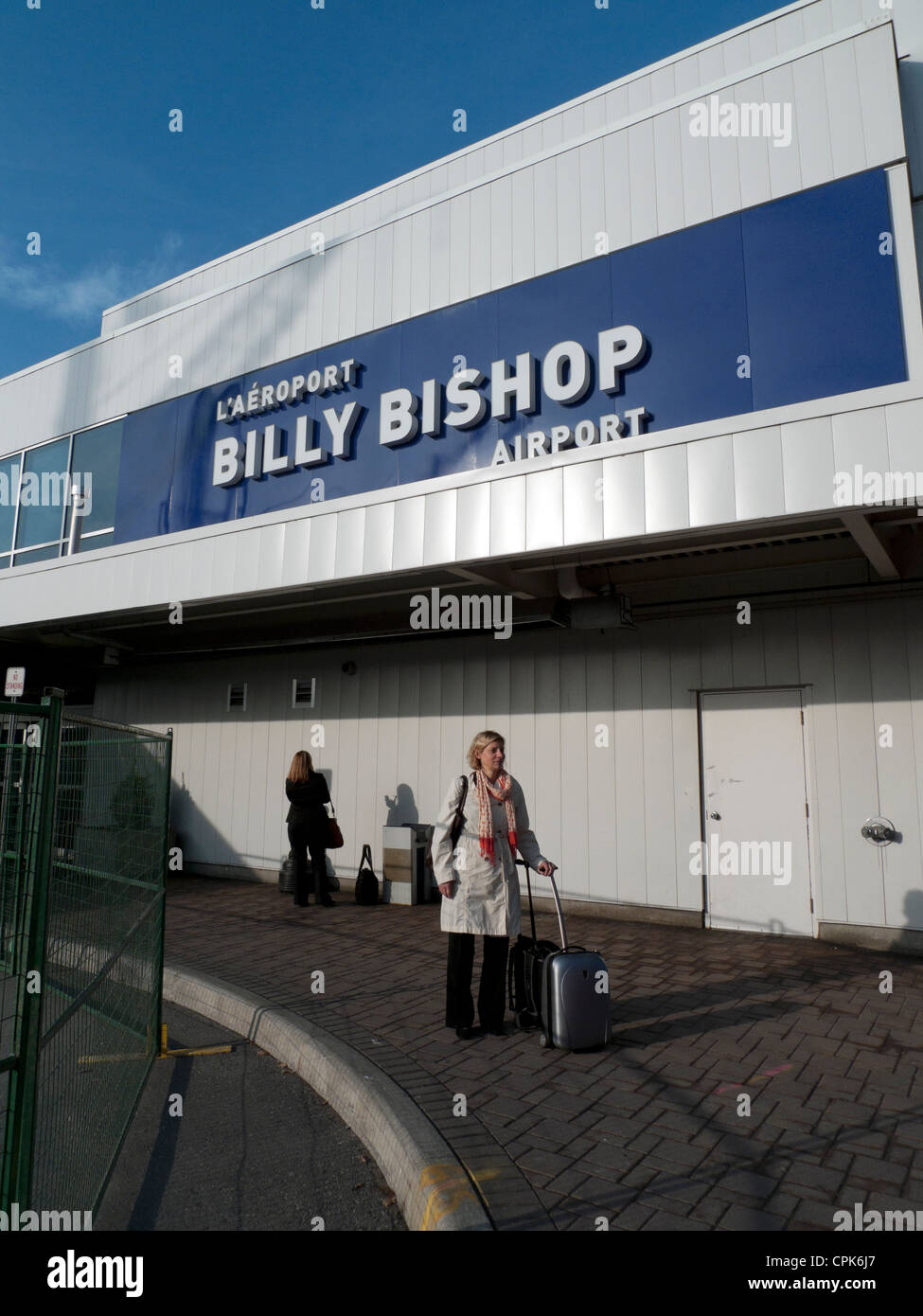 Businesswoman with luggage standing waiting outside Billy Bishop Airport Toronto Island Ontario Canada  KATHY DEWITT Stock Photo