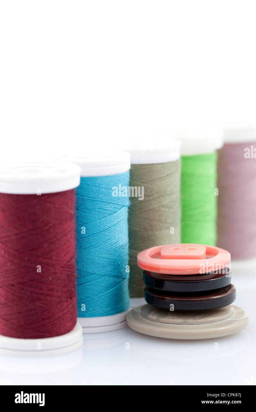 colourful cotton thread on spool and button Stock Photo