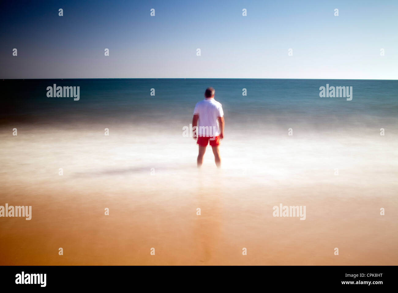 Man on a beach staring at the sea. Daylight long exposure shot by the ...