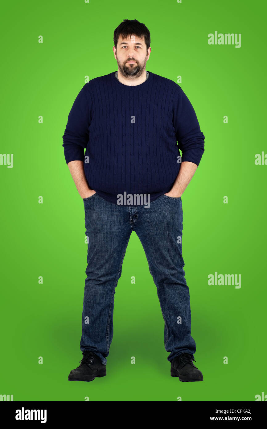 Complete body shot of a big guy looking at camera, real ordinary middle age man with weight problem in front of green screen Stock Photo