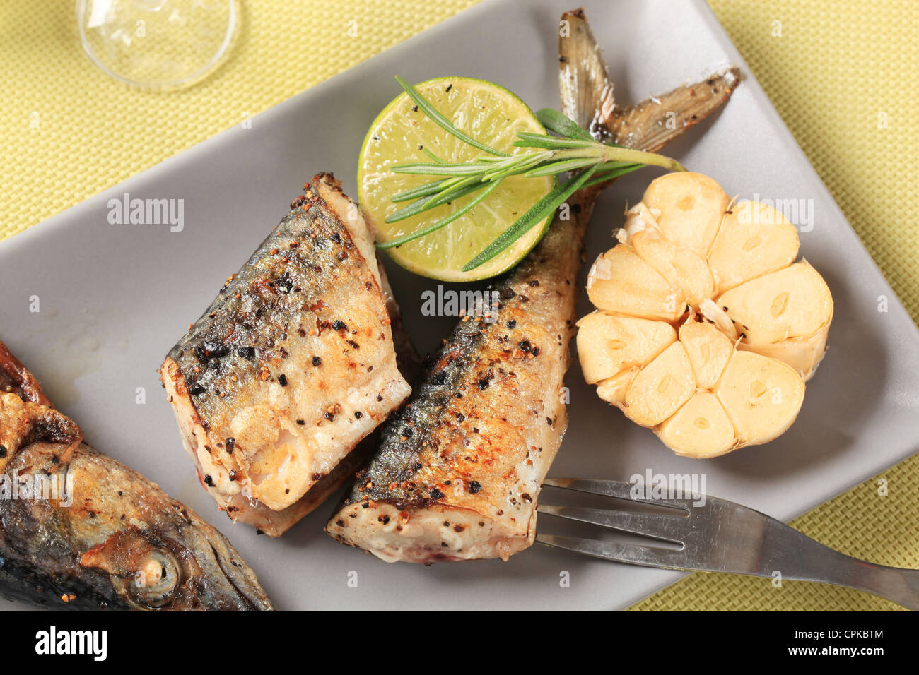 Pieces of pan fried mackerel and garlic Stock Photo