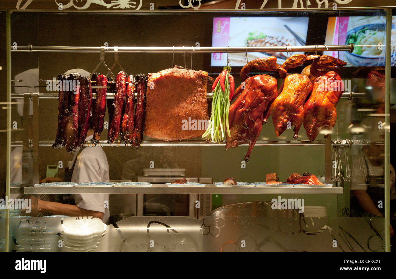 Chinese restaurant display window with barbecued meats, char sui pork, duck, sui yoke Stock Photo