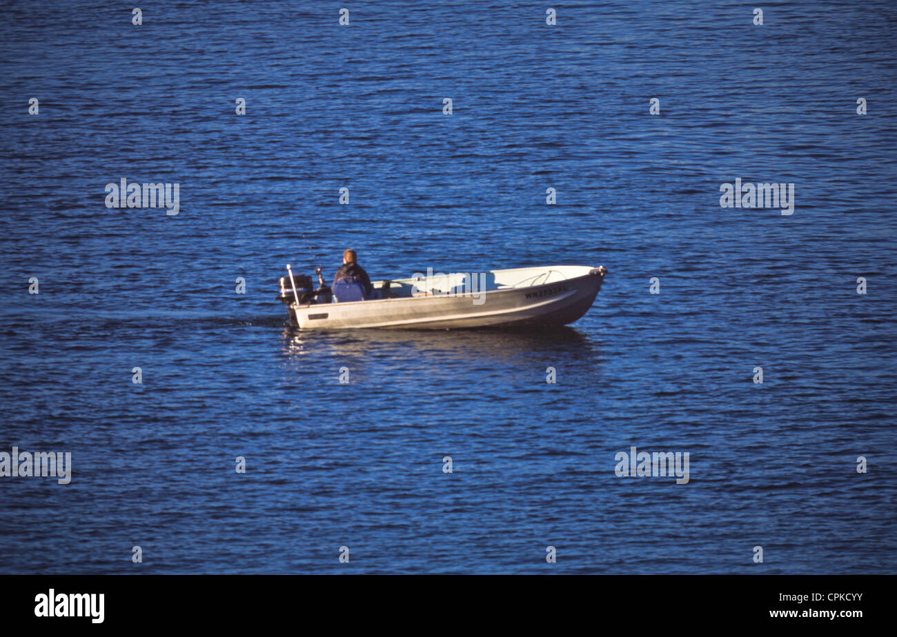 One man in small outboard fishing boat Stock Photo - Alamy