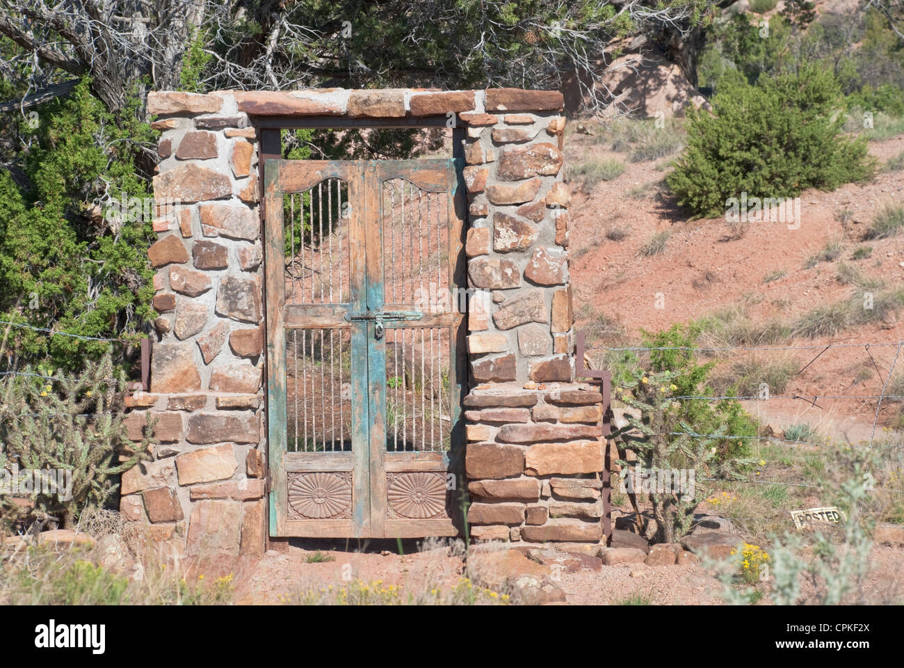 An old iron gate sits alone on vacant land near Madrid, New Mexico. Stock Photo
