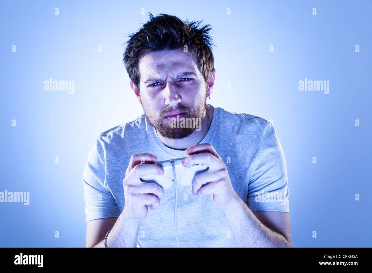 Concentrated Man Playing Videogames with Gamepad Stock Photo