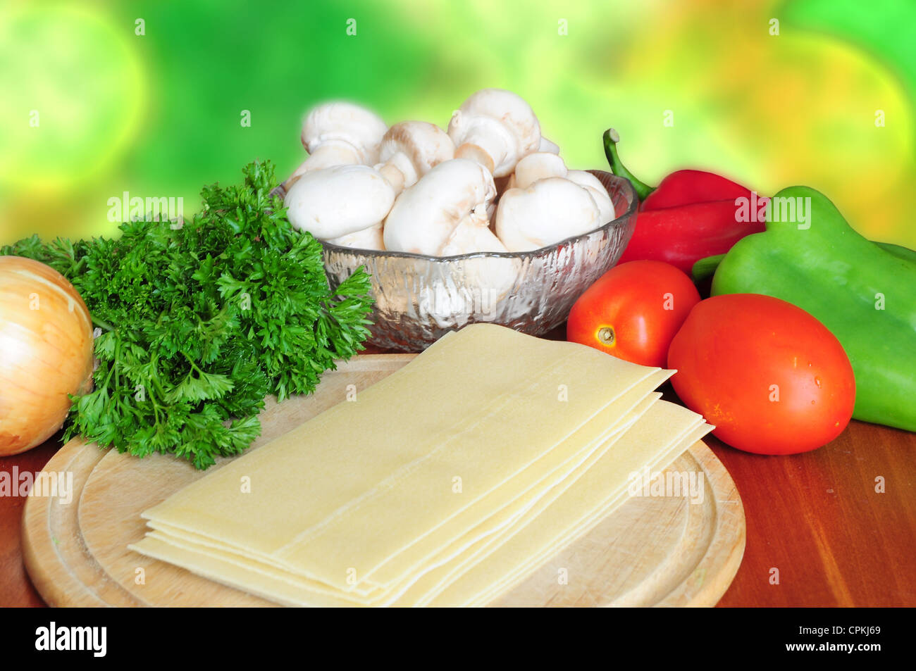 Ingredients for lasagna - tomatoes, pepper, parsley, mushrooms, onion, pasta Stock Photo