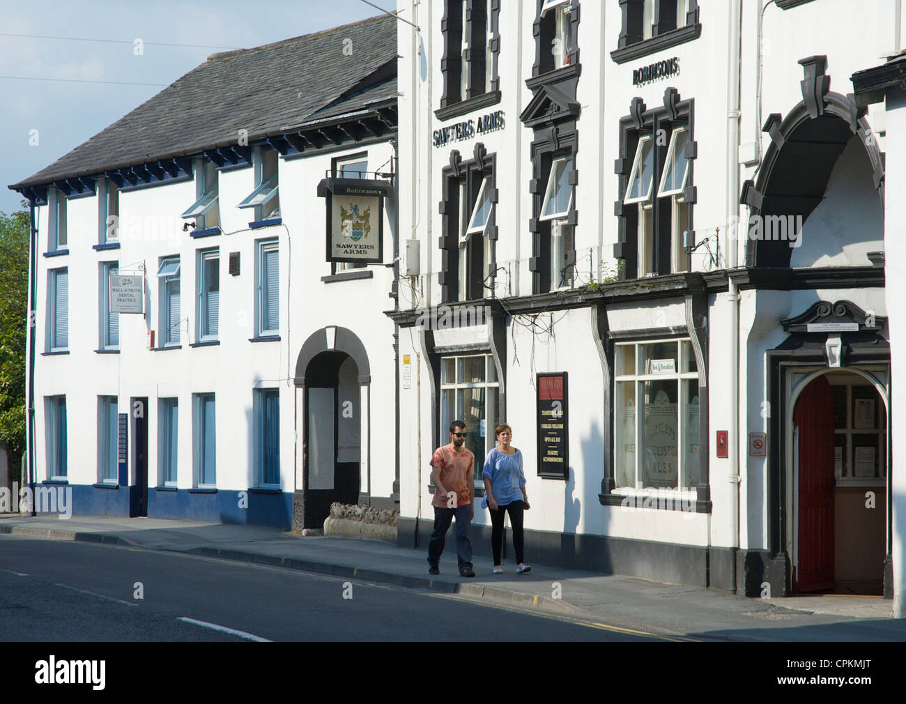 Man & woman walking past the Sawyers Arms, on Stricklandgate, Kendal