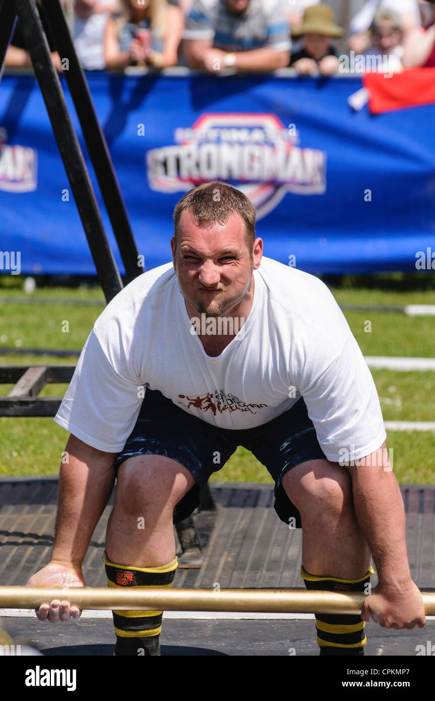 Man competing at a Strongman Competition, attempting to lift 230kg on a 2' bar Stock Photo