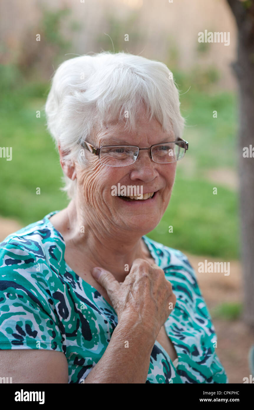 Grandmother laughing and making a tender gesture outdoors. Stock Photo