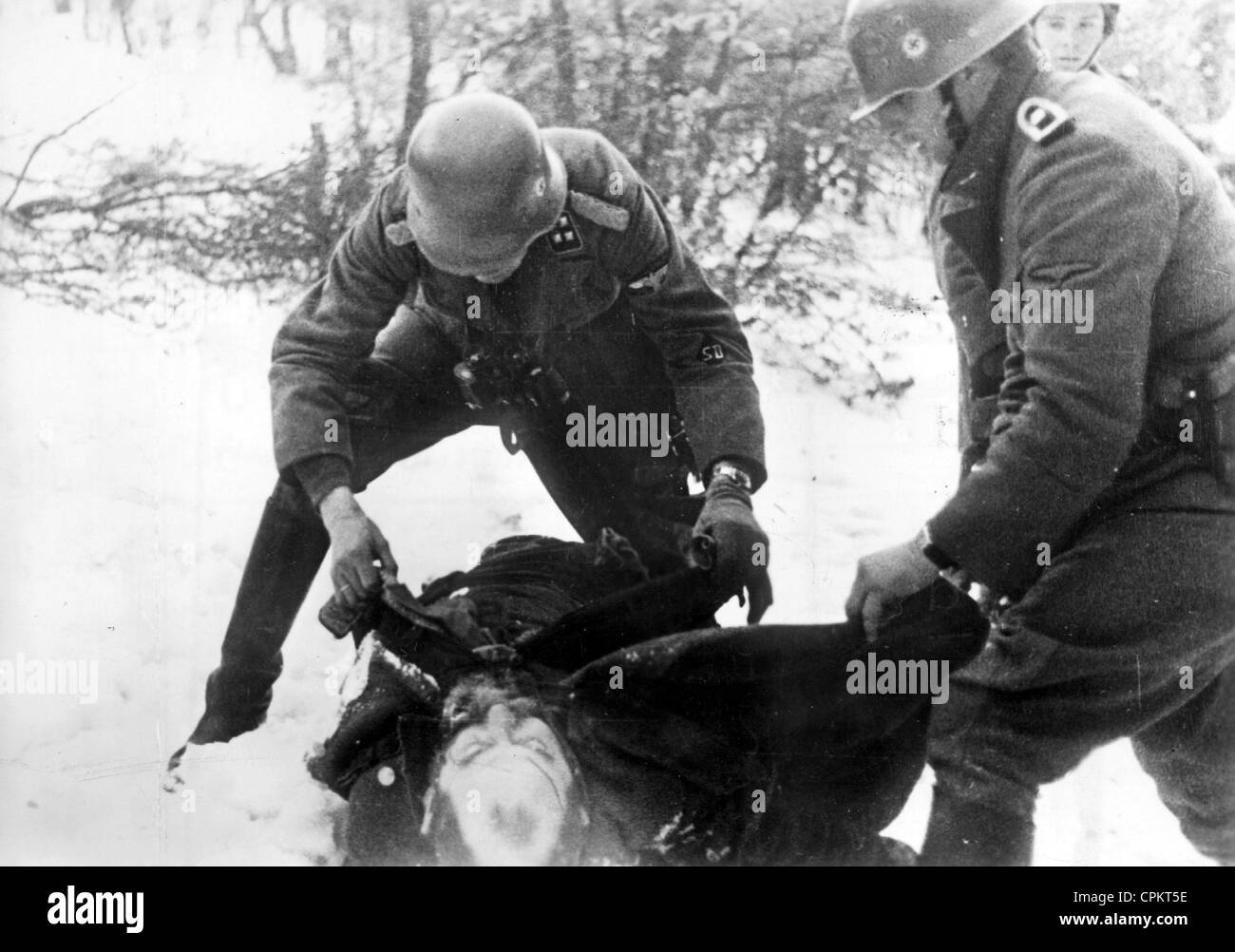 Soldiers of the Waffen SS on the Eastern front search a liquidated Jewish partisan, 1942 Stock Photo