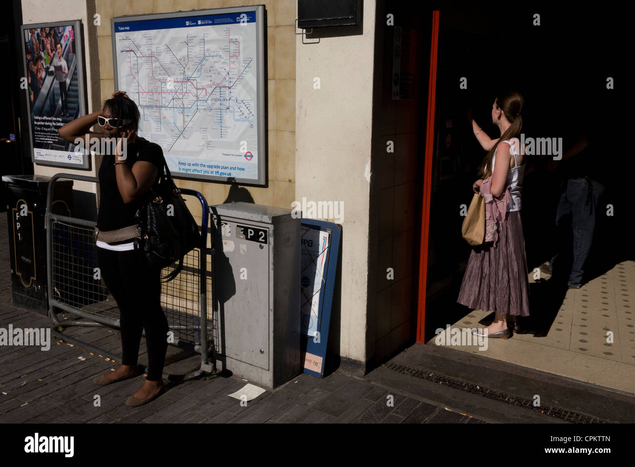 Londoners wearing sunglasses outside Sloane Square underground station. Stock Photo