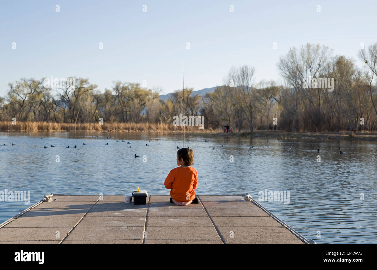 A boy sits on a dock fishing at Dead Horse Ranch State Park, Cottonwood