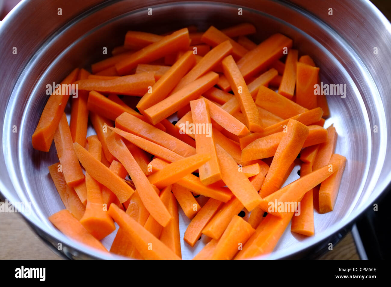 Fresh carrots washed and batoned in a colander Stock Photo