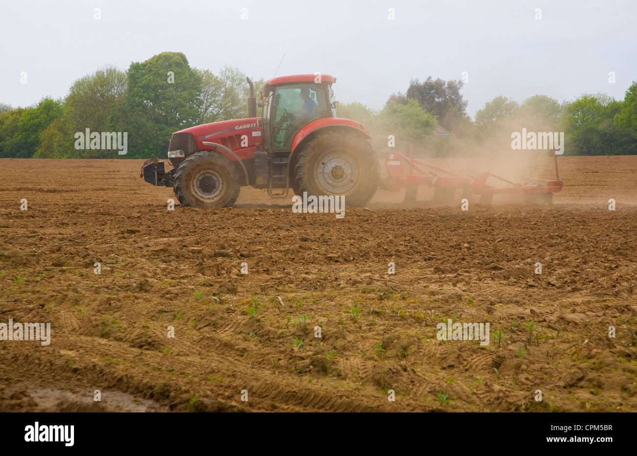 Red tractor harrowing field Shottisham, Suffolk, England Stock Photo ...