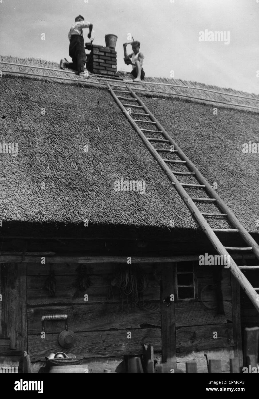 A thatched roof is repaired in the Memel Territory, 1934 Stock Photo