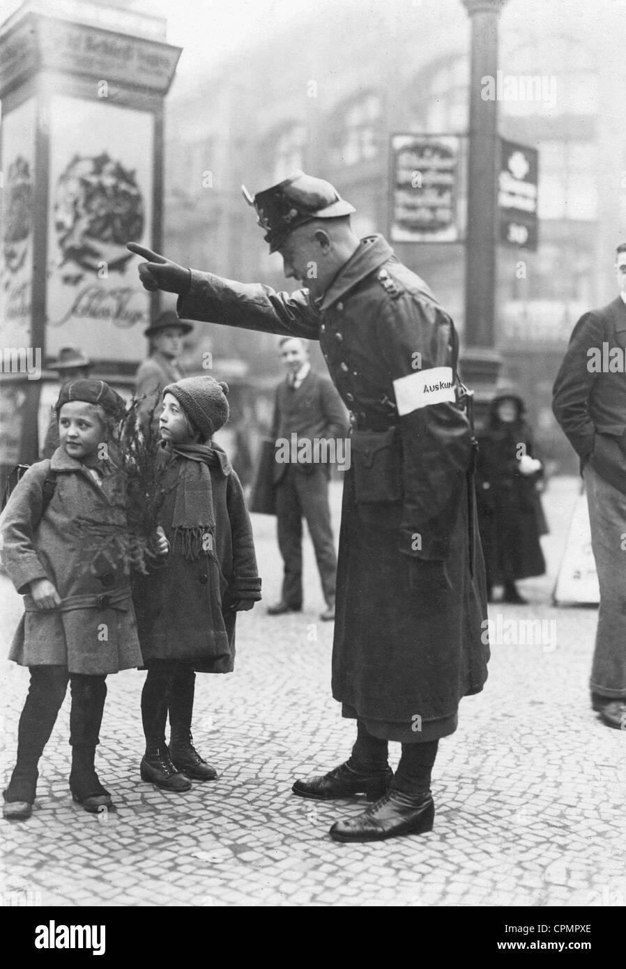 A policeman shows the way to children, 1923 Stock Photo