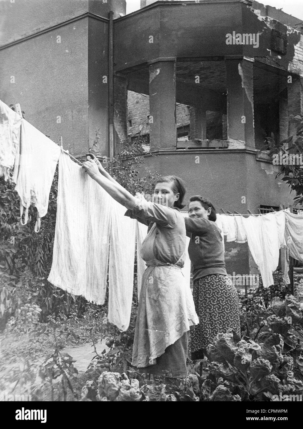 Women hang laundry up which they have retrieved from their house, 1943 Stock Photo
