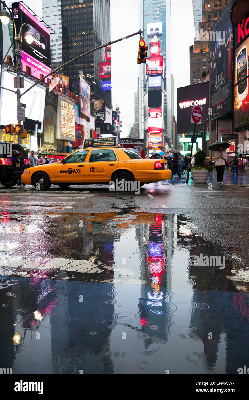 Iconic New York yellow taxis in Times Square, Manhattan. Reflections from  the rain and puddles Stock Photo - Alamy