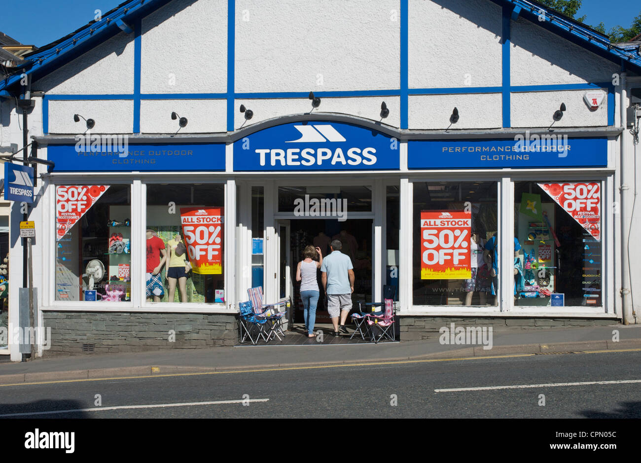 Middleaged couple entering outdoor clothing shop, Trespass, in Bowness