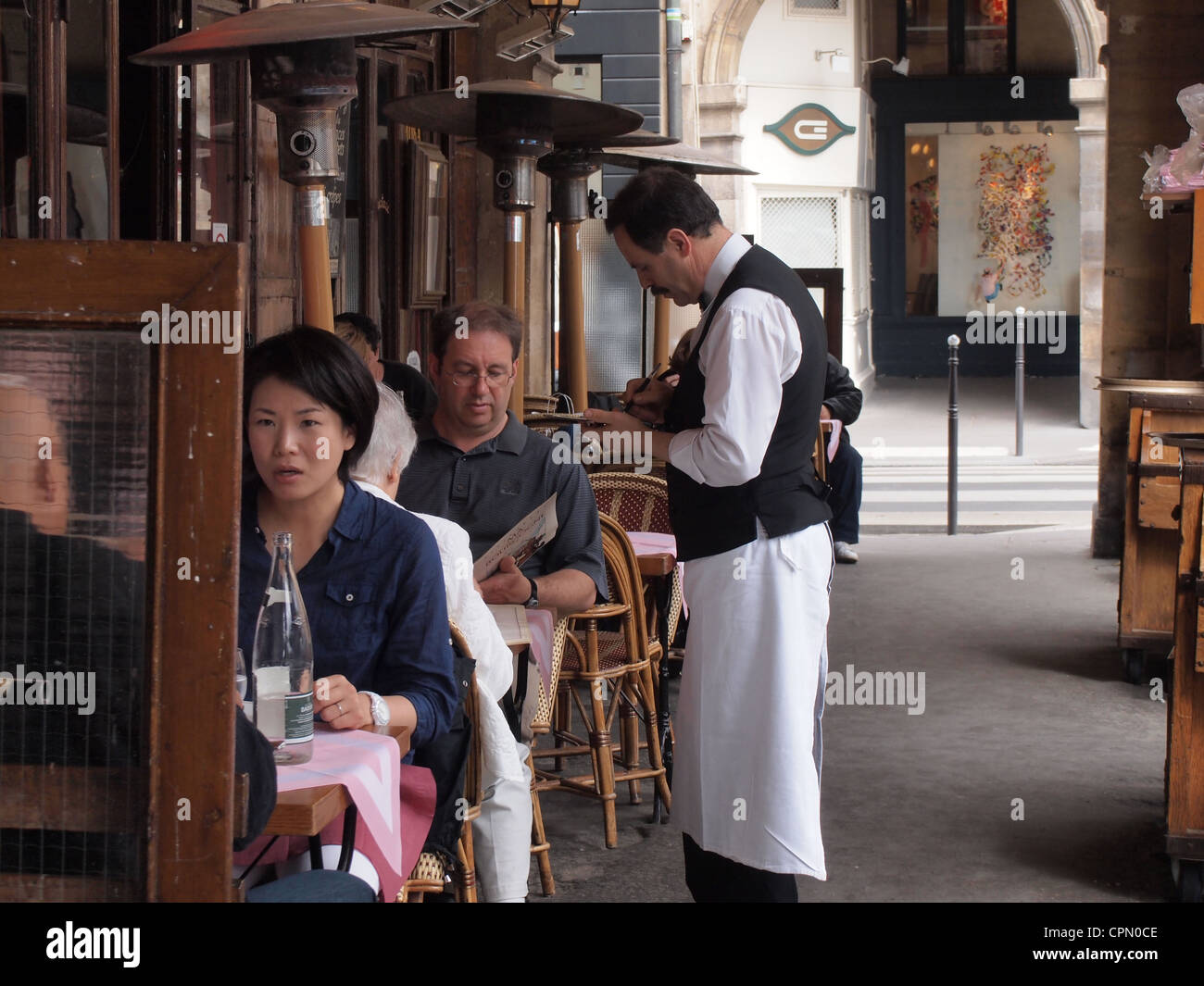 French waiter takes order from customer at a restaurant in Paris, France, May 9, 2012