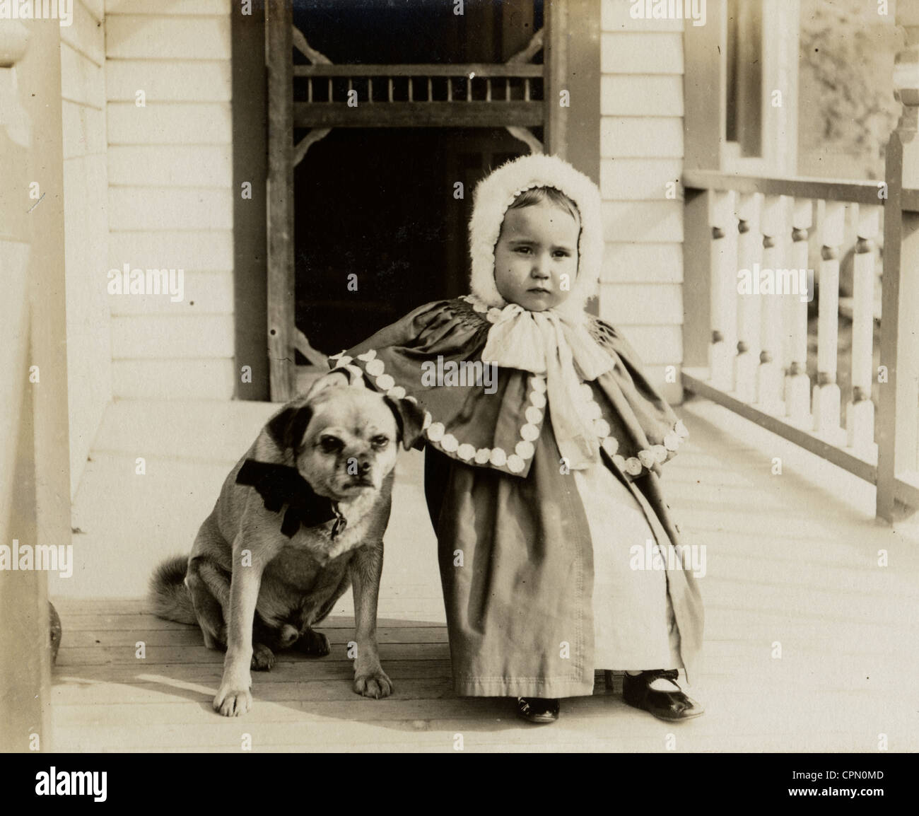 Cute Little Girl with Pug Dog on the Porch Stock Photo