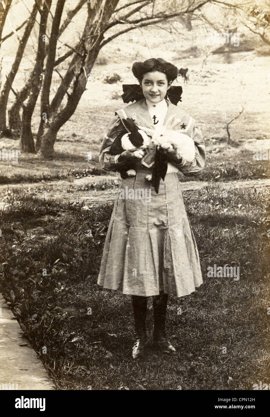Girl Wearing Sailor Suit with Two Pet Rabbits Stock Photo