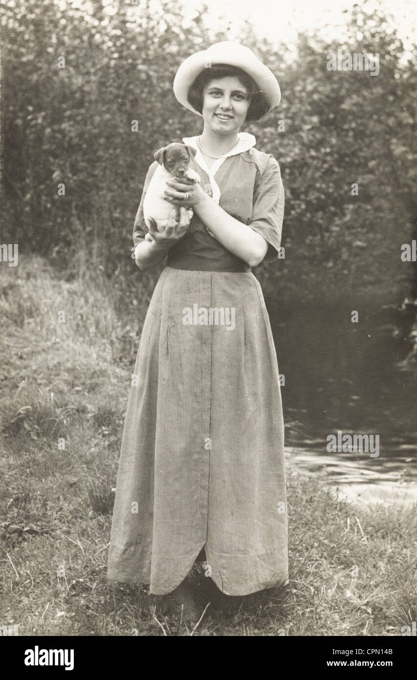 Young Woman Holds Tightly Wrapped Puppy Stock Photo