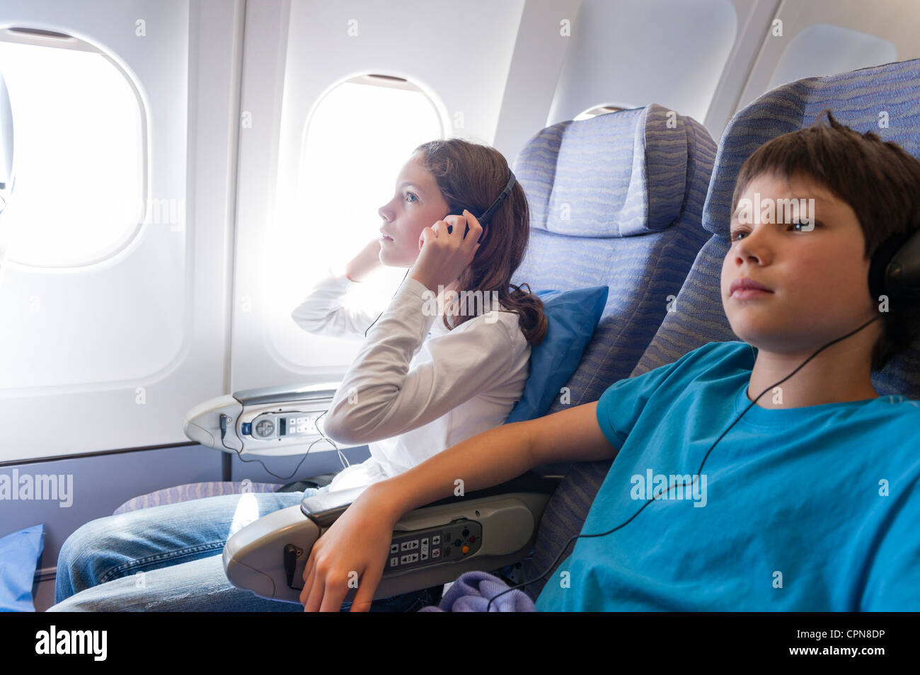 Children watching movie on airplane with headphones Stock Photo Alamy