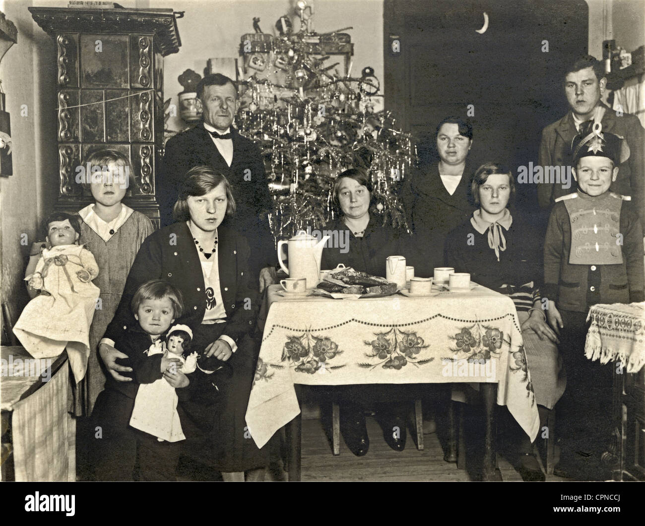 Christmas,family,celebrating together,Germany,circa 1932,parents,parent,married couple,married couples,brides,many,seven,7,child,kids,kid,brothers and sisters,brothers,brother,sister,sisters,people with many children,a family blesed with a large number of children,coffee table,coffee tables,fir tree,fir trees,festive,feastful,festal,decorated,Christmas tree,Christmas trees,Christmas presents,Christmas gifts,tree,trees,tight,strait,little,small,flat,housing conditions,room,rooms,parlour,tiled stove,tiled stoves,dis,Additional-Rights-Clearences-Not Available Stock Photo