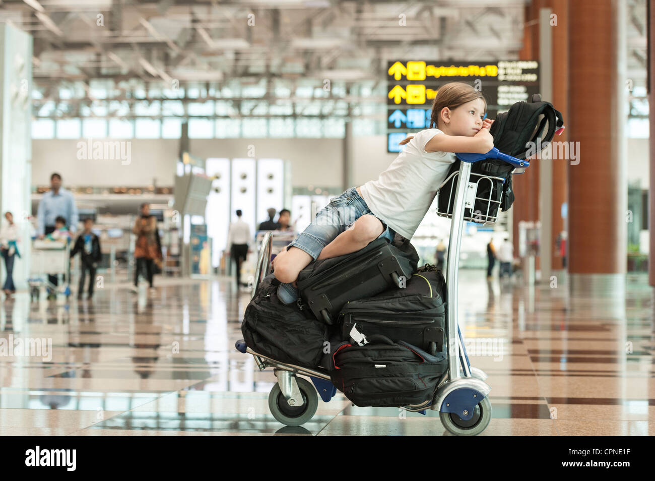 Girl sitting on top of luggage in airport Stock Photo Alamy