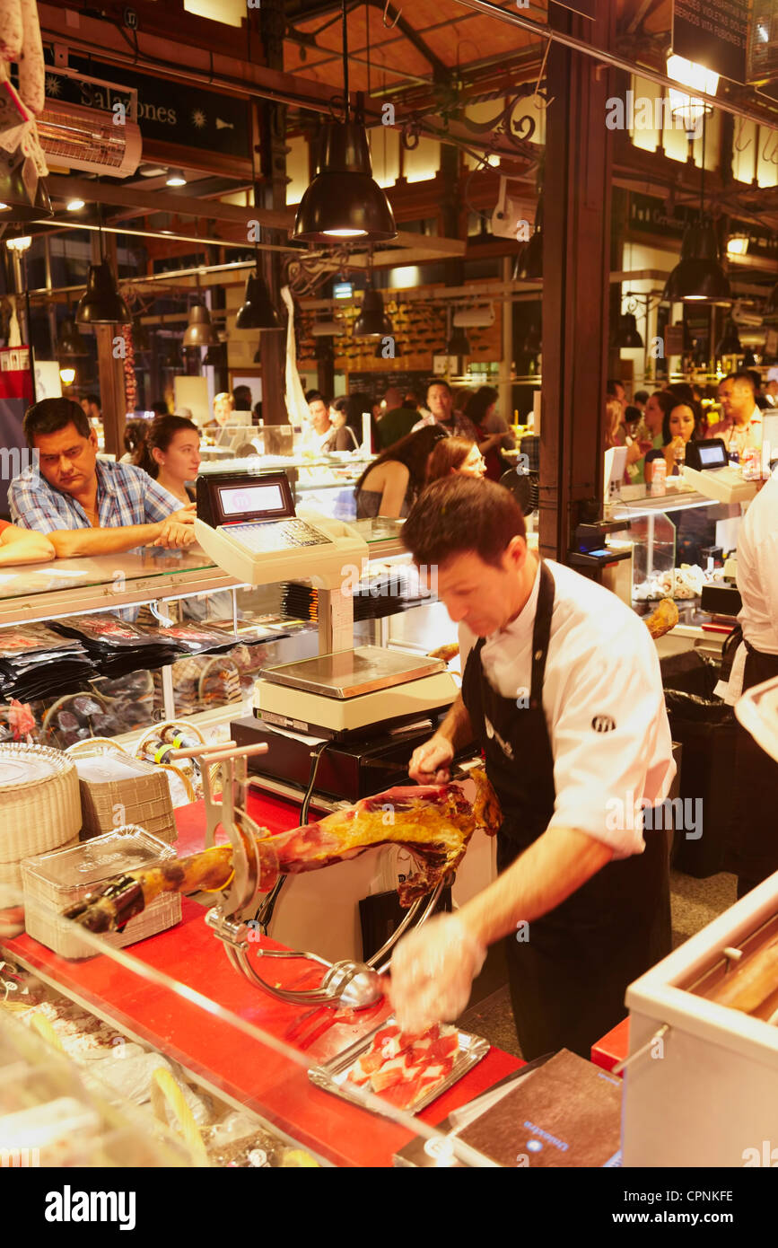 Butcher cutting cured iberian ham. Mercado de San Miguel. Madrid. Spain