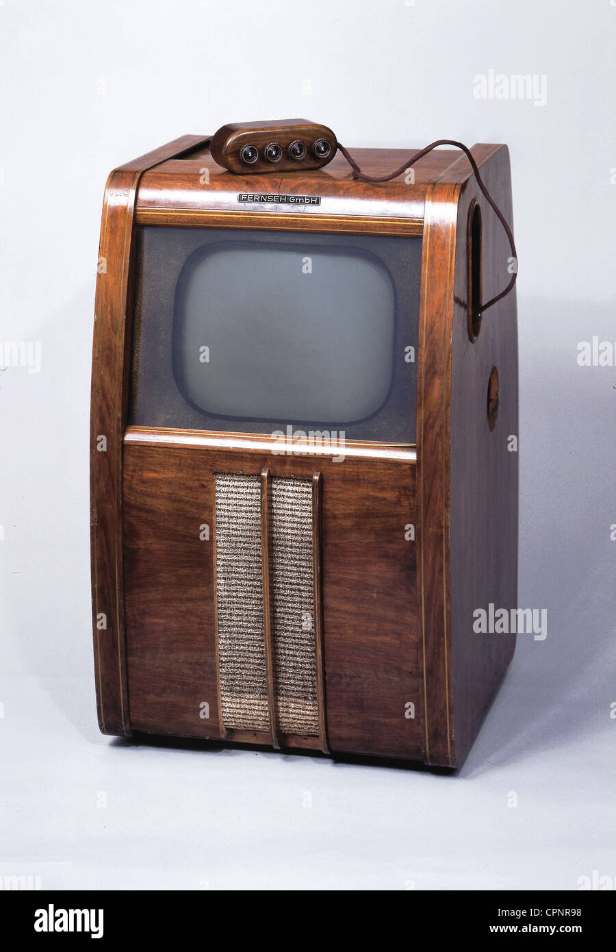 broadcast,television,standalone television set of the Fernseh GmbH,DE 10,with 40 centimeter screen size,remote control with cable,one of the first German postwar television sets,original price 1951: circa DM 2.500,Germany,1951,television console,television cabinet,cabinet receiver,standalone device,screen,screens,telescreen,monochrome,cable remote control,TV remote control,television set,TV,television sets,TV sets,TVs,TV set,TV history,media history,50s,television furniture,piece of furniture,pieces of furniture,wooden chassis,w,Additional-Rights-Clearences-Not Available Stock Photo