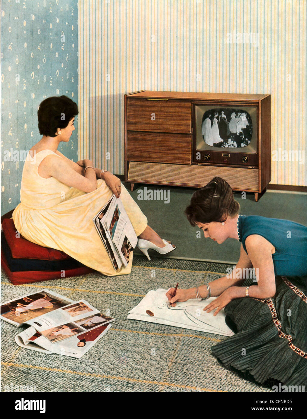 broadcast,television,viewers,women sitting in front of television set,interested in fashion,advertising for Siemens television console FTR 2,television-radio-phono combination,chassis: exotic woods,walnut tree,original price 1957: DM 2.450,Germany,1957,fashion magazine,fashion magazines,television viewer,television viewers,teenager,teen,teenagers,teens,leisure time,free time,spare time,leisure-time activity,leisure-time activities,young,lady,ladies,women,TV history,media consumption,media use,flat,interior furnishings,economic ,Additional-Rights-Clearences-Not Available Stock Photo
