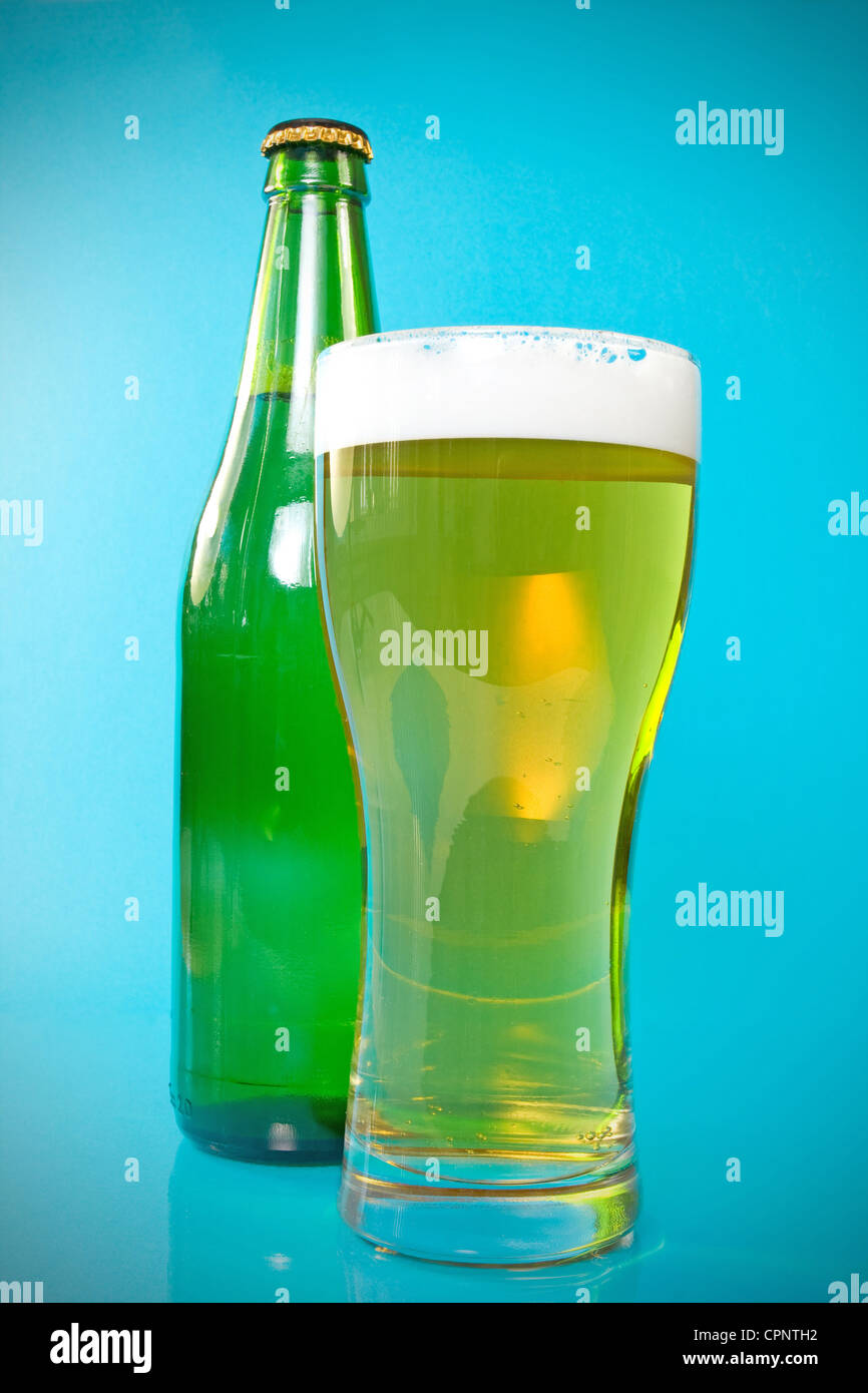 beer bottle and glass over a blue background Stock Photo Alamy
