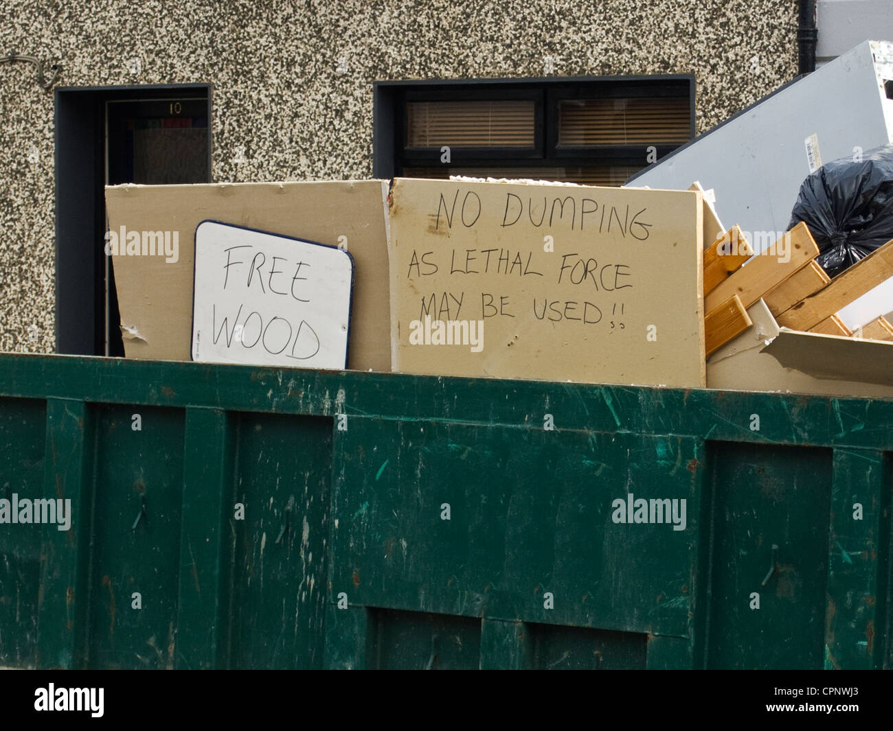 Humourous signs on a large skip or dumpster in Skerries, county Dublin, Ireland Stock Photo