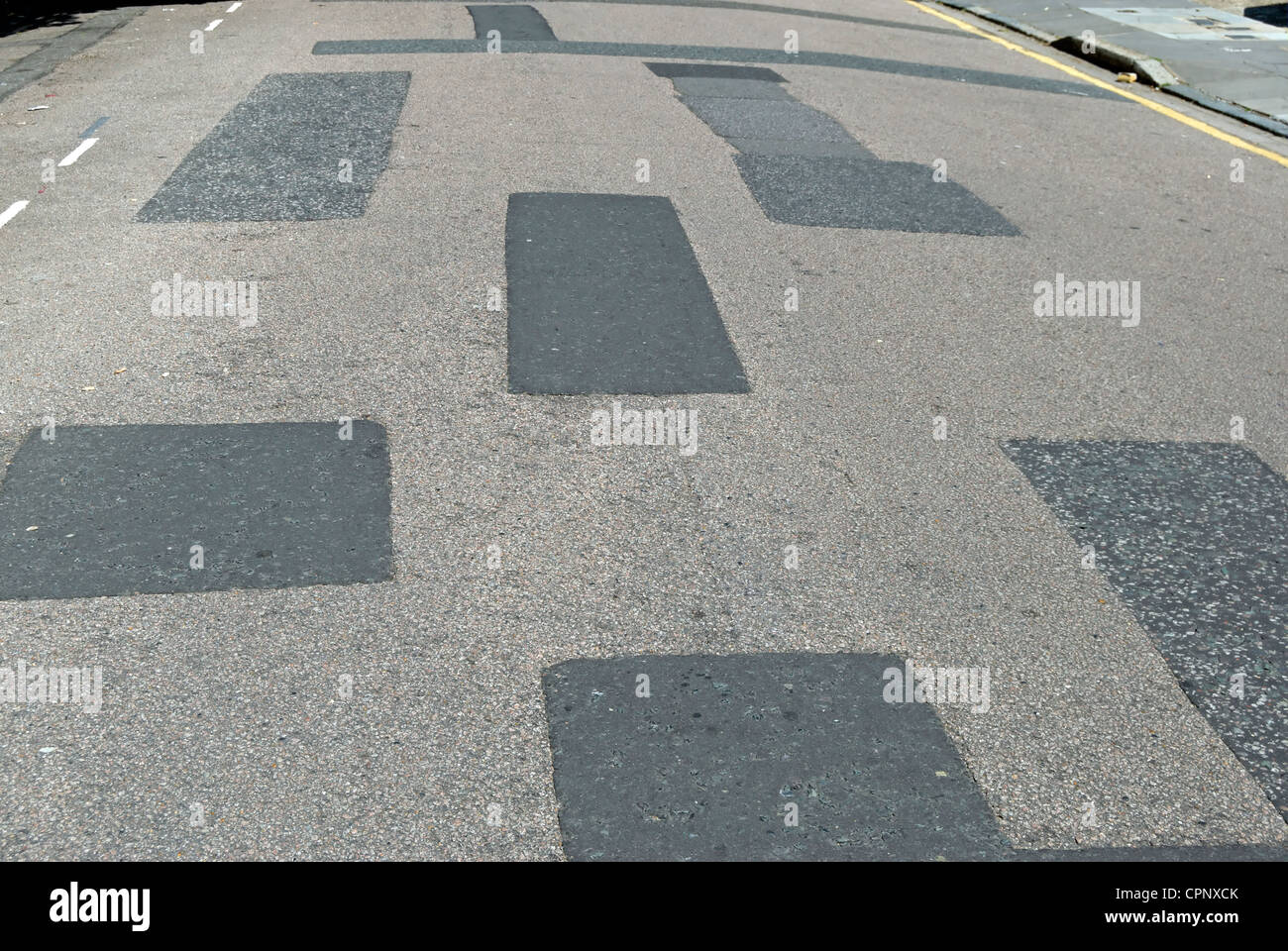 road surface repairs creating a patchwork effect, in ealing, west london, england Stock Photo