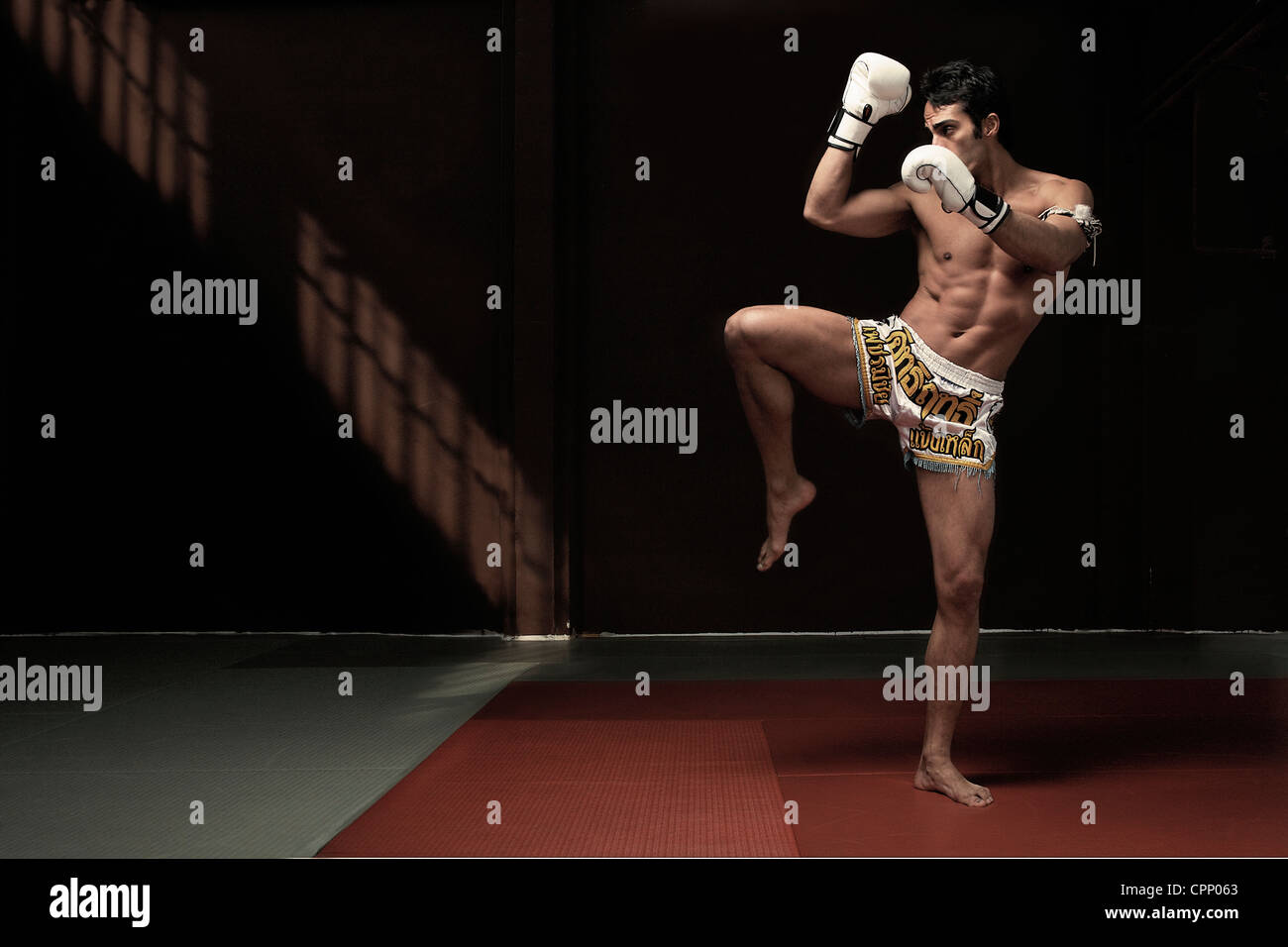 Boxer kicking on mat Stock Photo