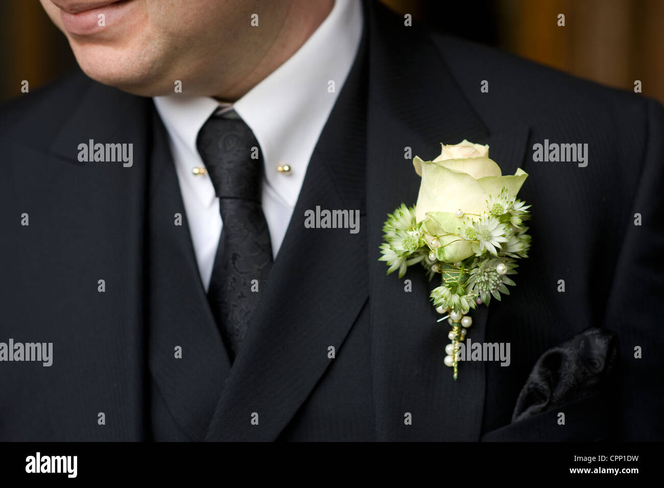 man at a wedding or funeral wearing black suit with rose buttonhole Stock Photo