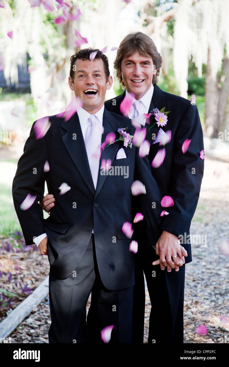 Gay wedding couple being showered with rose petals.  Stock Photo