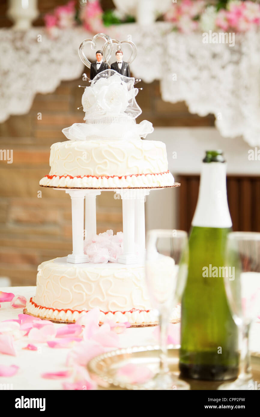 Wedding Cake Decorated With Two Grooms On A Reception Table With