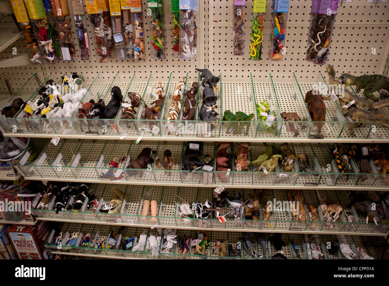 Shelves of plastic wild animals, reptile, dinosaur figures in a store. Stock Photo