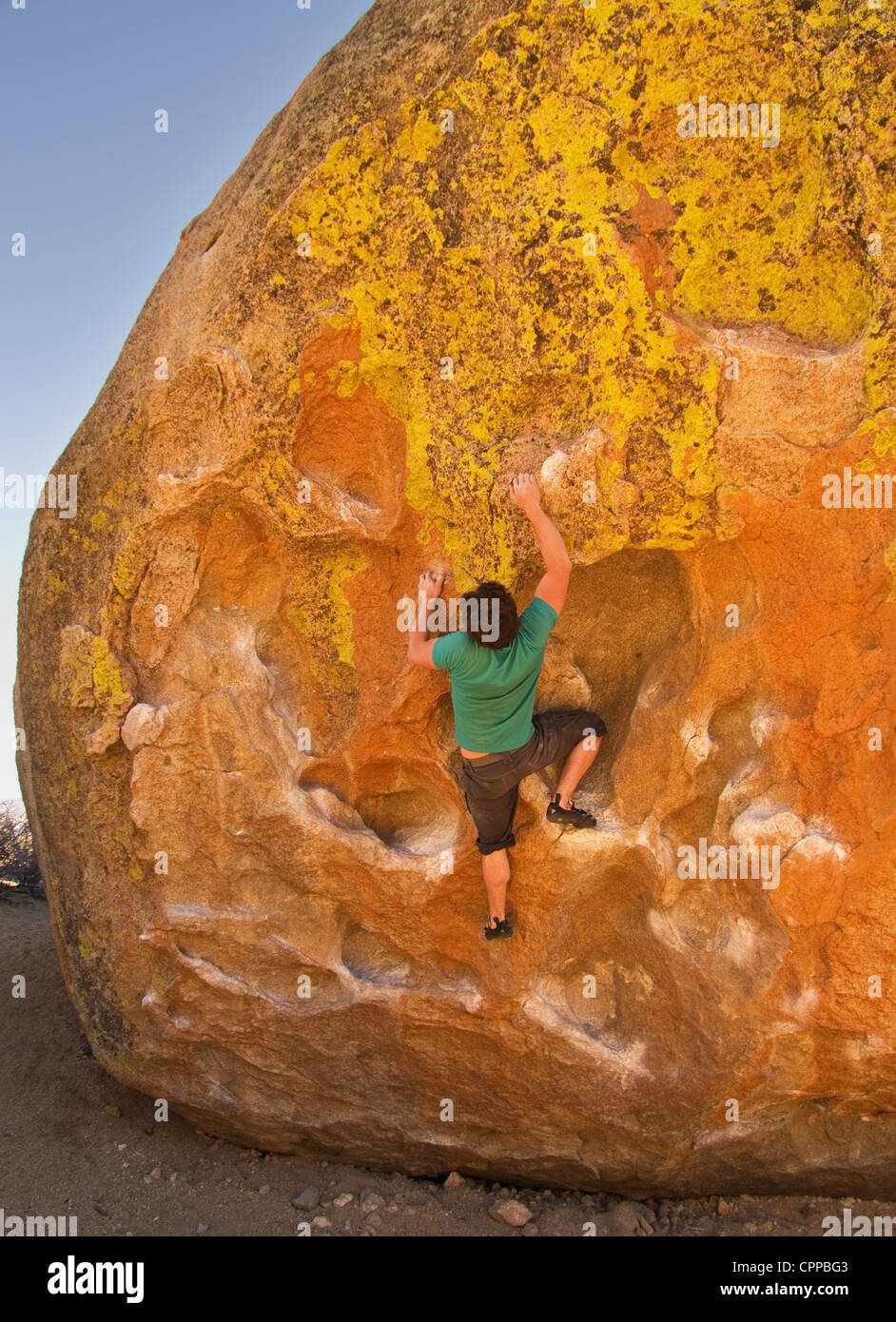 man rock climbing on a large boulder at the Buttermilk bouldering area Stock Photo