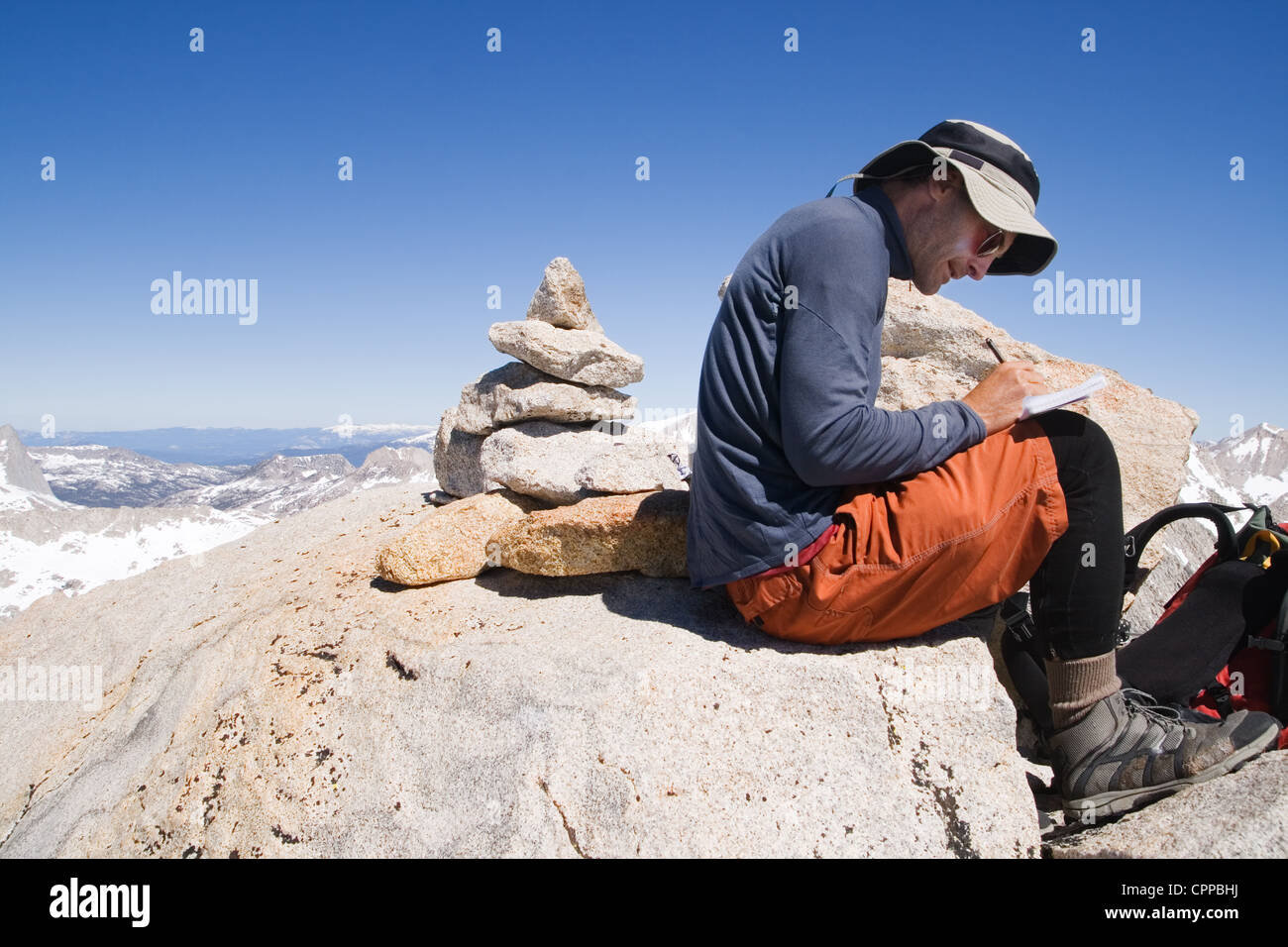 a man signing the summit register on the peak of Mount Merriam Stock Photo